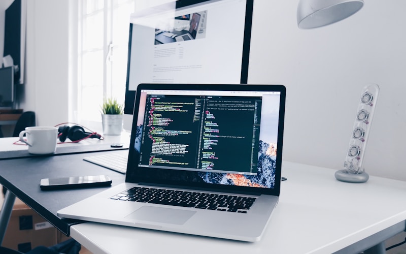 Laptop screen displaying HTML code on a developer desk