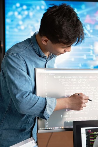 Web developer looking at code structure and website elements on monitor