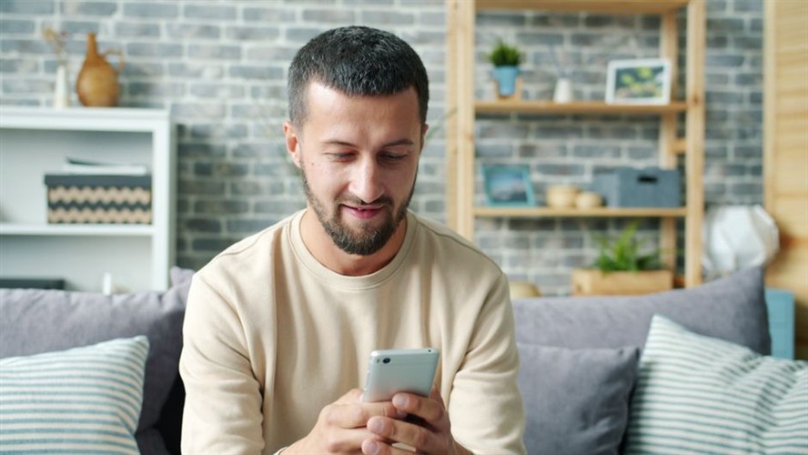 Smiling Person Using Smartphone For Facebook Marketing 2026